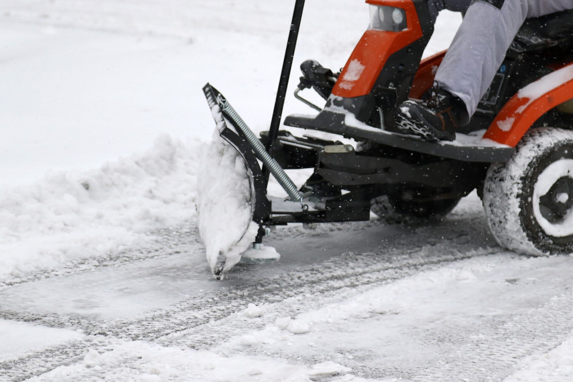 Riding snow mower and removing snow from a parking lot